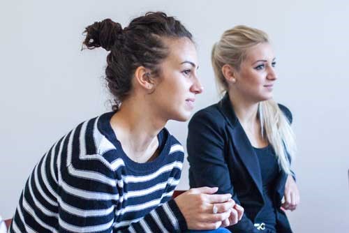 Två tjejer som sitter bredvid varandra